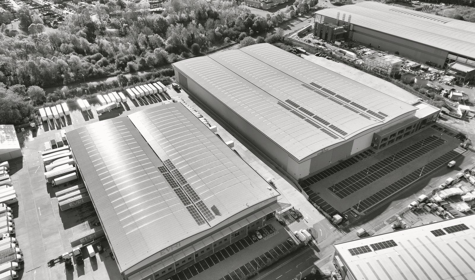 Aerial photograph of a UK logistics estate, printed in graphite duotone